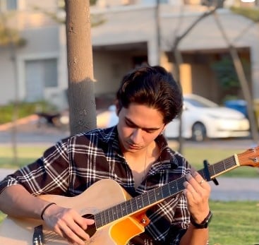 Samar Jafri while playing a guitar