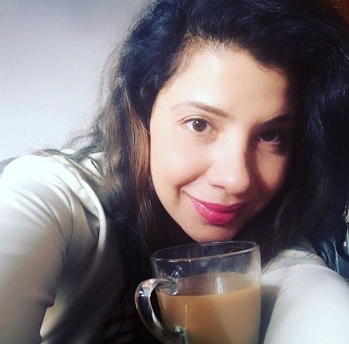 Sambhavna Seth with a cup of coffee