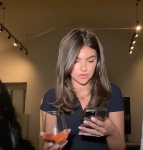 Samie Elishi holding a glass of wine