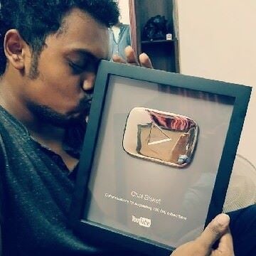 Sandeep Raj holding a silver play button