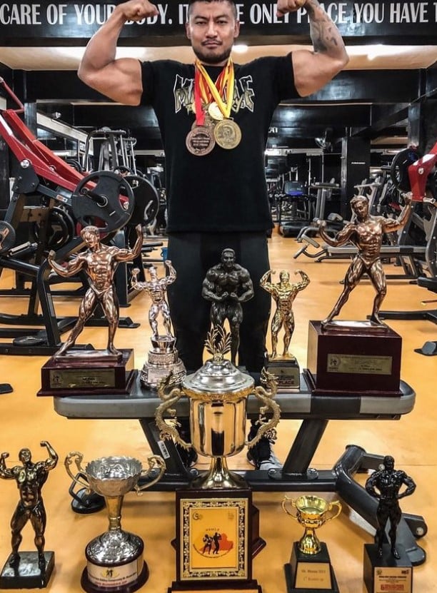 Sangay Tsheltrim posing with his trophies and medals