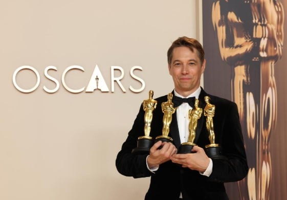 Sean Baker posing with his Oscars