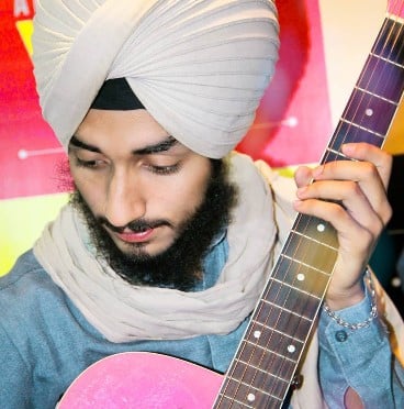 Sehaj Arora while playing a guitar