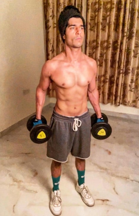Shaan R Grover posing during a home workout with dumbbells