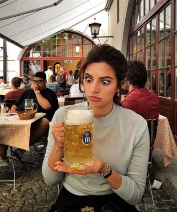 Shama Sikander holding a mug of beer