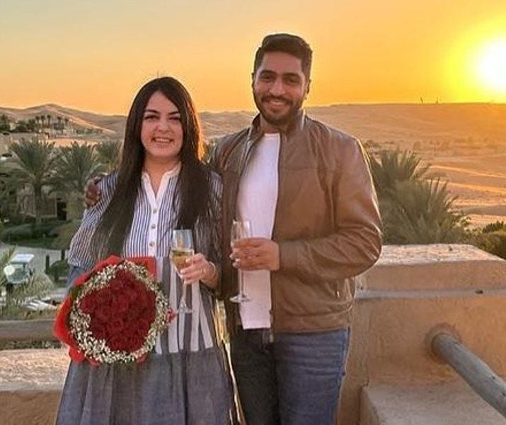 Shanelle Irani and Arjun Bhalla, holding a glass of champagne