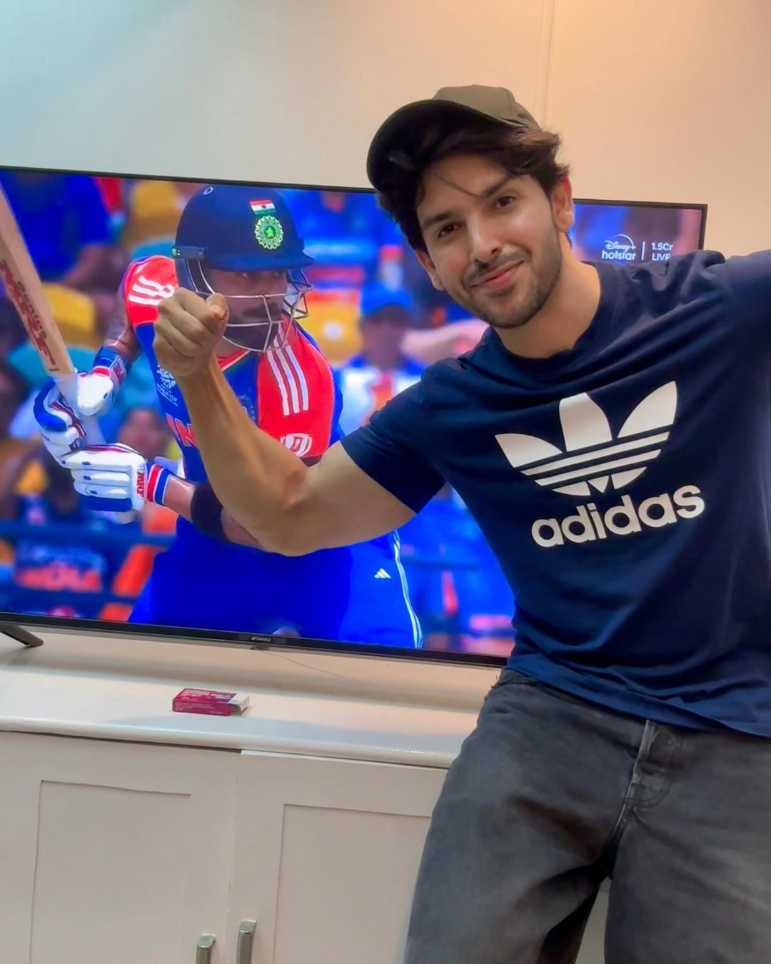 Shehzada Dhami posing in front of his television watching cricket