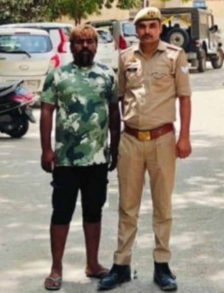 Sherpal Bairagi with a police official after he was arrested