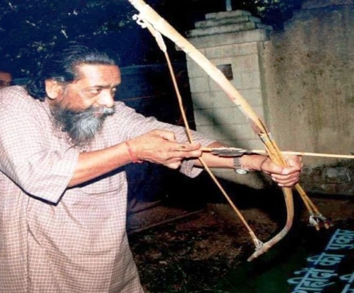 Shibu Soren holding and aiming a bow and arrow