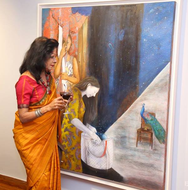 Shovana Narayan holding a glass of wine at an art exhibition