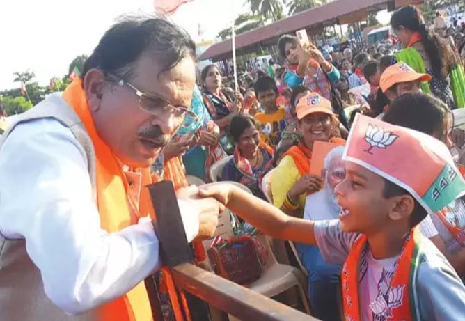 Shripad Naik while listening to a child during a political rally