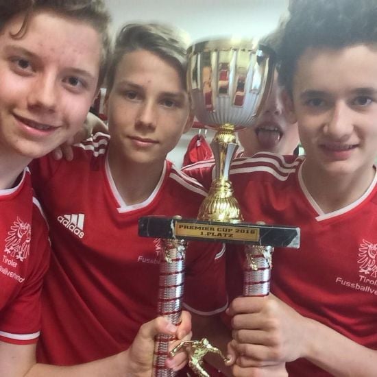 Stefan Inthal (middle) and his teammates with the Premier Cup football tournament trophy