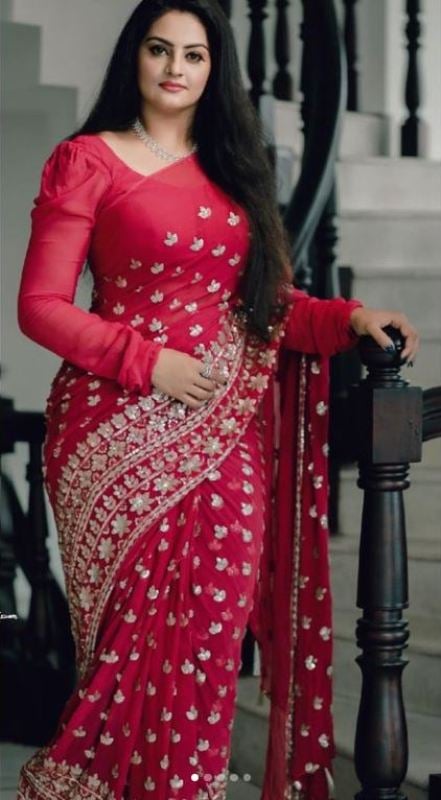 Suchithra Nair posing in a studded saree on a staircase