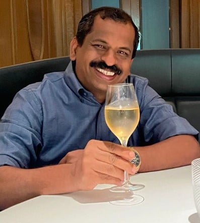 Suresh Pillai posing with a glass of alcohol