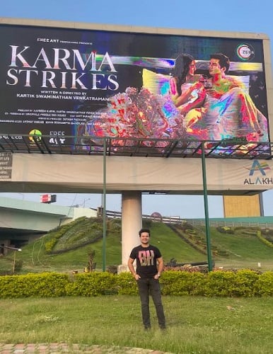 Suyash Pachauri with the hoarding of Karma Strikes