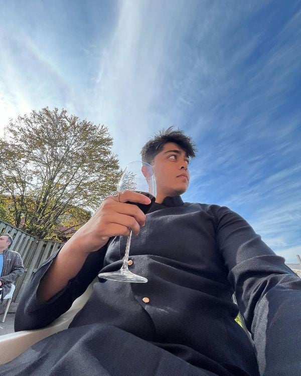 Tirth Parsana holding a glass of red wine