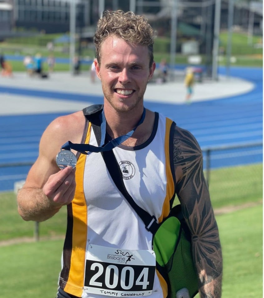 Tommy Oswald showing his win medal from the Australian Masters Games 200m sprint