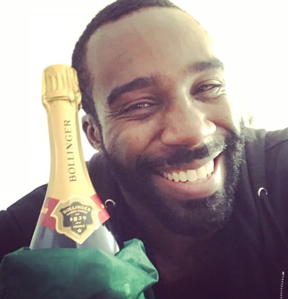 Tramell Tillman posing with a bottle of champagne