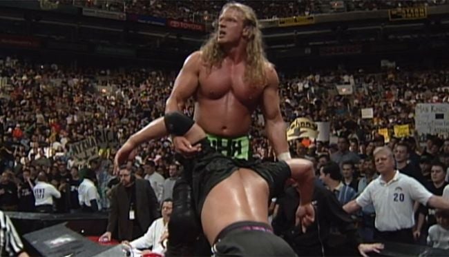 Triple H looking at Kane holding Chyna through the titantron screen before performing a Pedigree on The Rock
