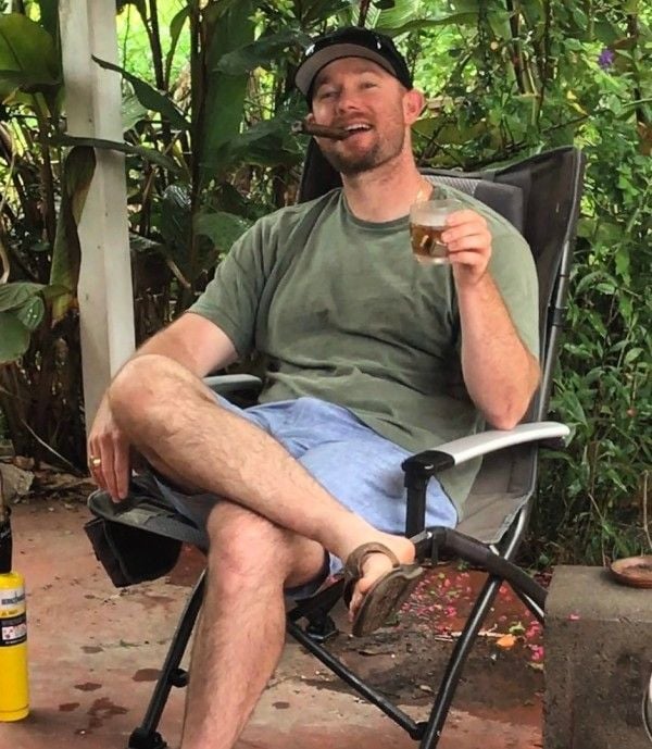 Ty Carter smoking a cigar while holding a glass of alcoholic beverage