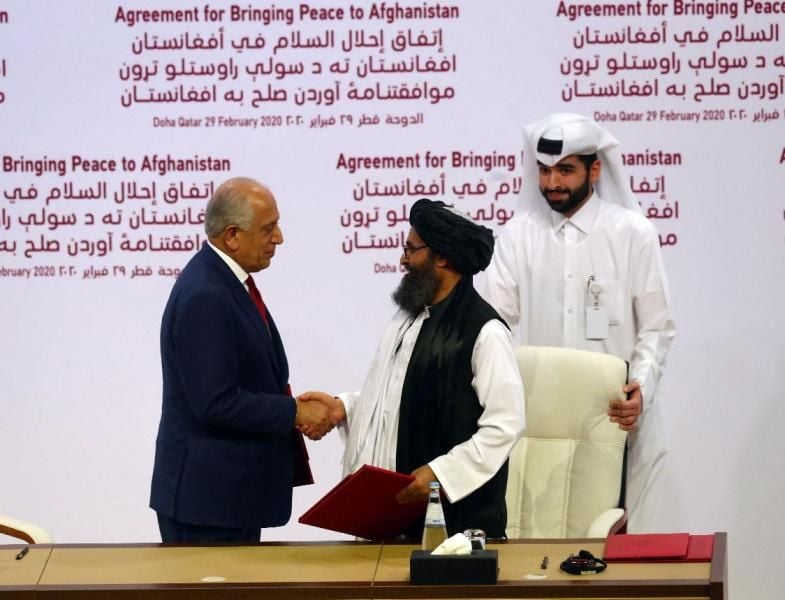 US representative Zalmay Khalilzad (left) and Baradar (right) sign the Agreement for Bringing Peace to Afghanistan in Doha, Qatar, on 29 February 2020