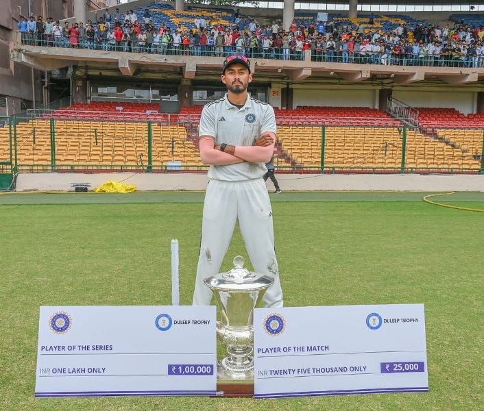 Vidwath Kaverappa posing with Duleep Trophy title and other rewards