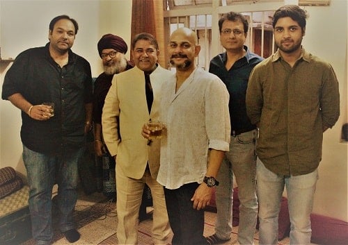 Vijayant Kohli holding a glass of alcohol