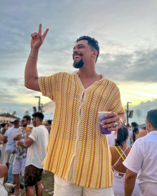 Vinícius Nascimento holding a cup of alcohol