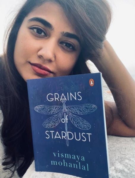 Vismaya Mohanlal posing with her book titled 