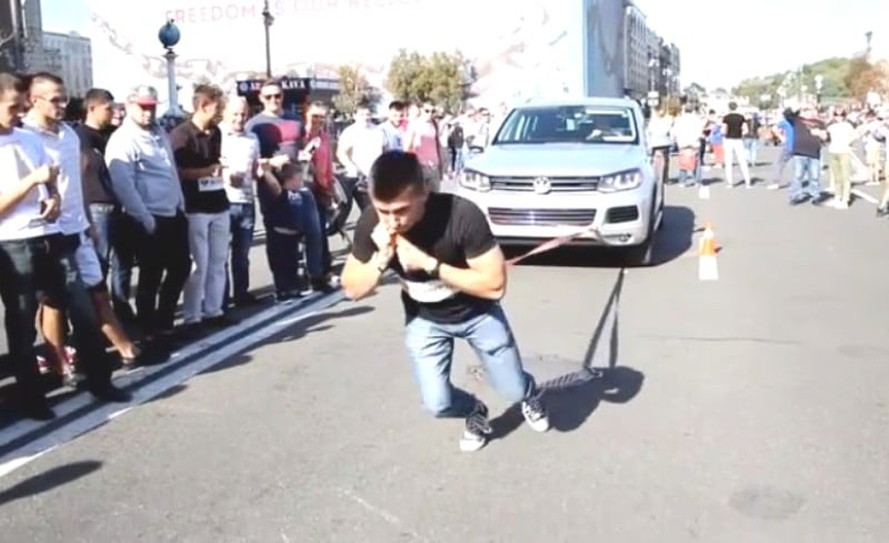 Vladimir Shmondenko pulling a Volkswagon car