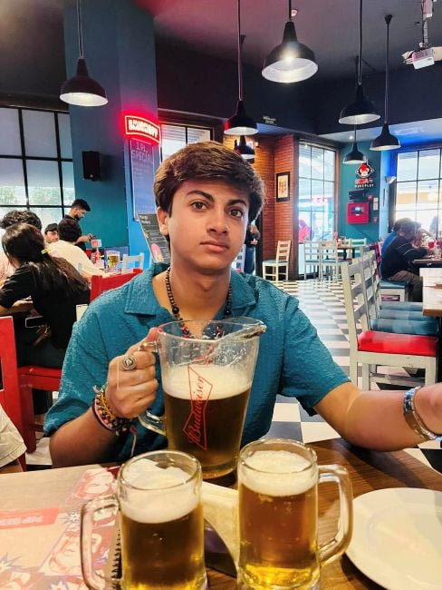 Yash Bhojwani with a jug of alcohol